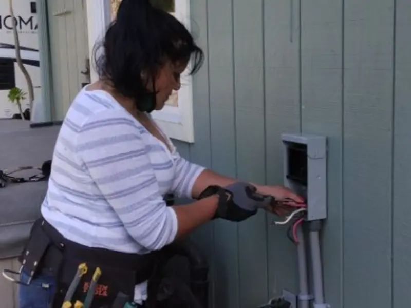 Licensed electrician wiring an exterior subpanel in Evansdale
